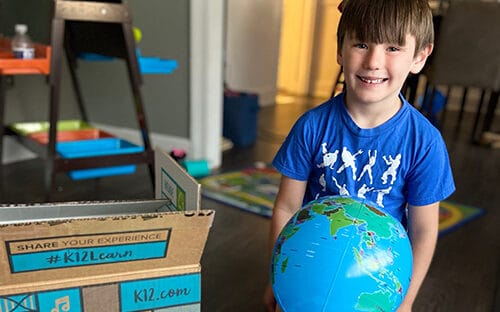 boy playing with earth ball and boxes