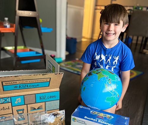 boy playing with earth ball and boxes